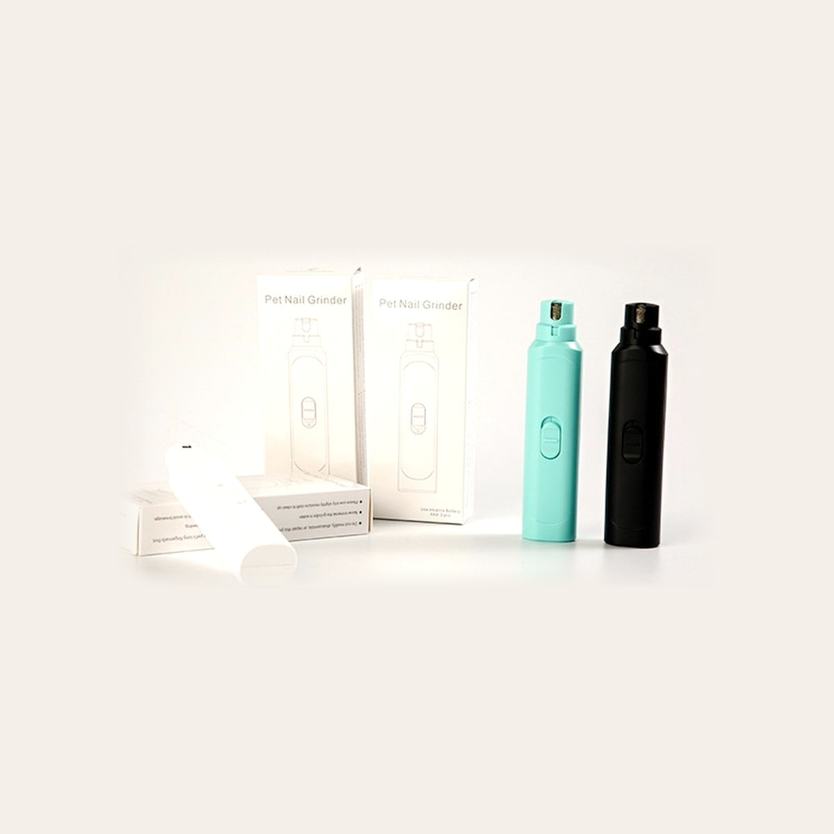 All three colourways of the Quiet Paws Nail Grinder - Elegant White, Emerald Green and Ink Black - beside their retail boxes